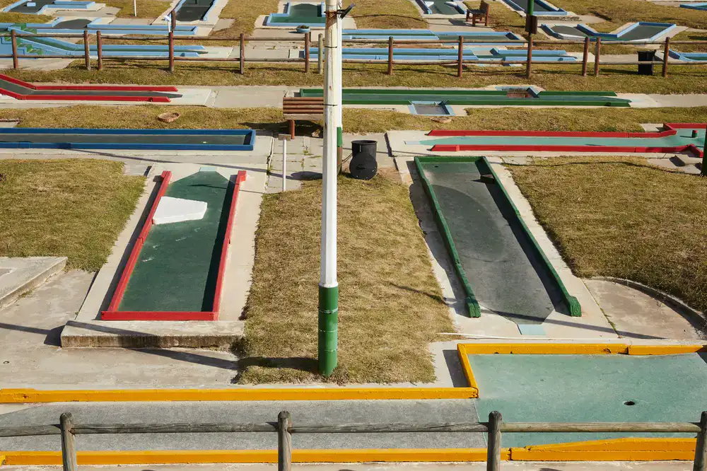 Lush green mini-golf course viewed from above at dusk