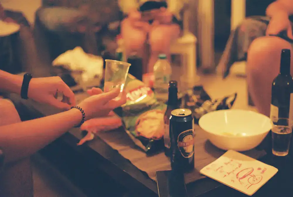 People celebrating with drinks and snacks at a lively table